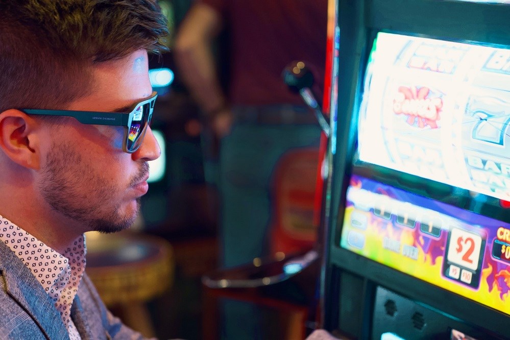 Guy in sunglasses at a slot machine