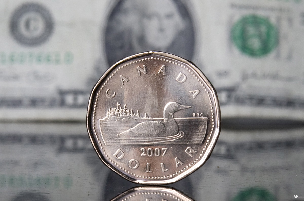 Loonie with greenback in background