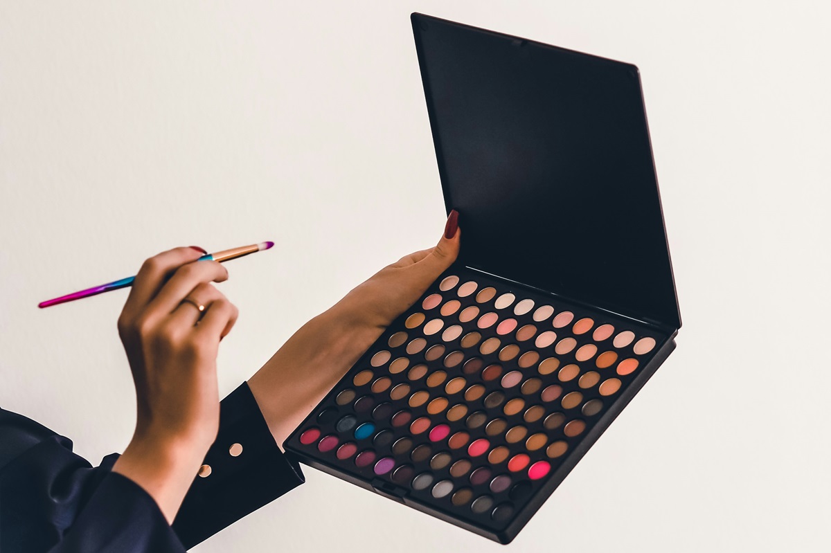 Person holding makeup brush and palette
